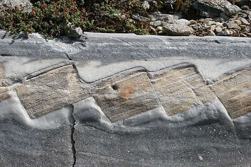 Asymmetrische Boudins von Dolomit- in Kalkmarmor im Liegenden der Simplonstörung. Der rechtssinnige Schersinn im Foto (Blick nach SE) entspricht einer abschiebenden Bewegung nach SW. Kaltwassergletscher oberhalb vom Simplonpass.