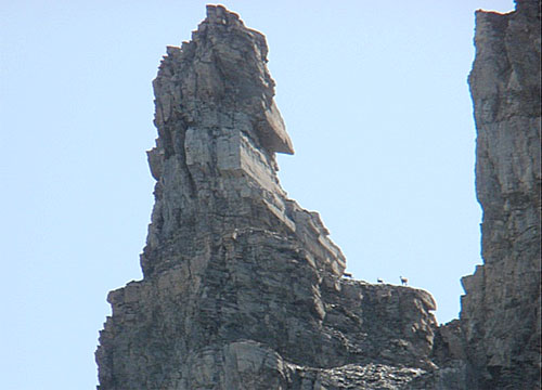 Exponierte Bogenmauer unter einer absturzgefährdeten Felssäule